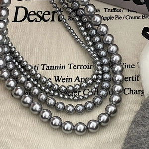 Gros plan sur un collier de perles grises multicouche avec un éclat métallique chic