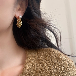 Detailed view of French vintage earrings featuring pearl studs and golden cluster tassels