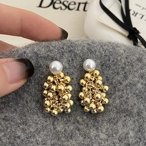 Detailed close-up of French vintage gold metal ball and pearl cluster tassel earrings