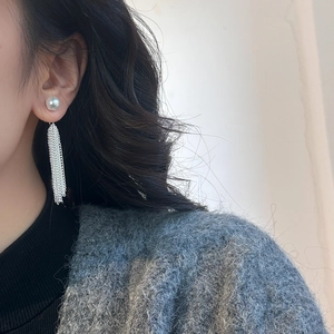 Elegant silver waterfall tassel earrings with white pearls shown on a female model