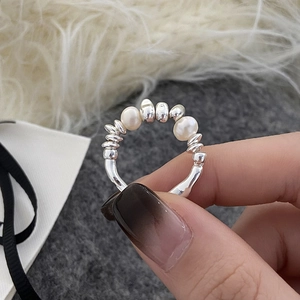 Elegante anello con perle d'acqua dolce bianche e sfere d'argento mostrato sulla mano