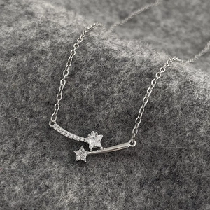 Macro shot of silver star-shaped zircon pendant on grey textured wool background
