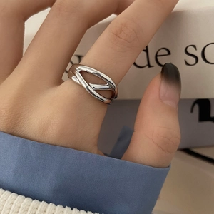 Detailed view of a silver intertwined hollow ring with a polished metallic finish