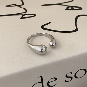 Macro detail of minimalist silver adjustable open ring with asymmetric teardrop design