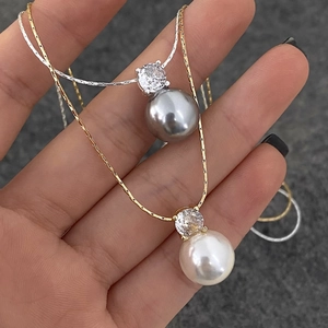 Detail of elegant pearl pendant necklaces with cubic zirconia in gold and silver finishes