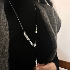 Silver metal leaf tassel necklace for women, minimalist long pendant on dark sweater