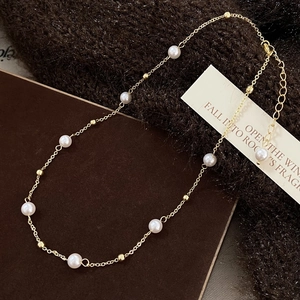 Detail of freshwater pearl necklace with gold beads, lobster clasp and extension chain