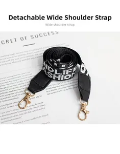 Detail of detachable wide woven shoulder strap with fashion lettering and gold hooks