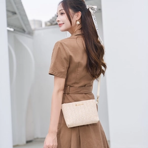 Chic beige woven straw crossbody bag with striped texture and gold logo for summer