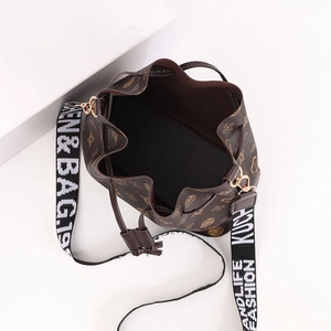 Vintage brown drawstring bucket bag with floral monogram print and stylish wide strap
