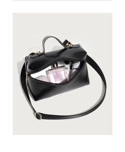 Internal view of glossy leather box bag showing capacity for phone and perfume
