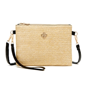 Sac bandoulière minimaliste en paille tissée avec bandoulière cuir et trèfle doré