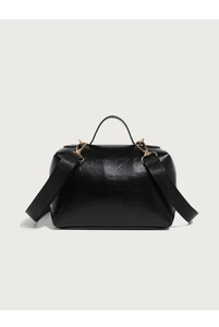 Close-up of black glossy leather box bag with gold metal hardware and wide strap