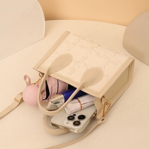 Chic beige textured crossbody bag with gold hardware showing interior storage capacity