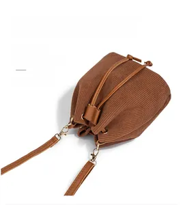 Detail of brown corduroy bucket bag texture with drawstring and dual straps