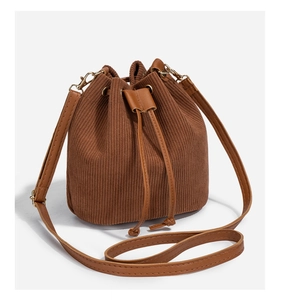 Detail of vintage brown corduroy bucket bag texture with drawstring and gold hardware