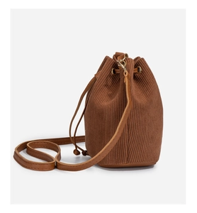 Detailed close-up of brown corduroy bucket bag with vertical stripe texture and gold hardware