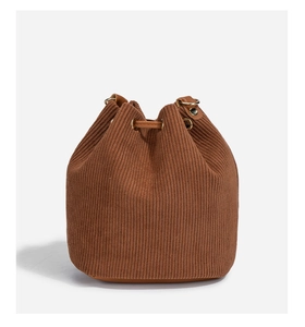Detail of caramel brown corduroy drawstring bucket bag with vertical stripe texture