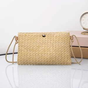 Detail of woven straw crossbody bag featuring a golden round metal buckle and rope strap