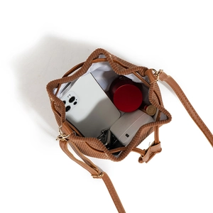 Brown corduroy drawstring bucket bag with leather strap showing spacious inner storage