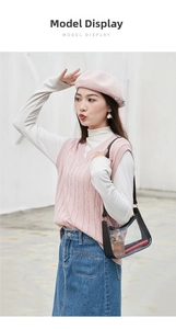 Outdoor shot of clear transparent handbag with black trim paired with pink knit vest