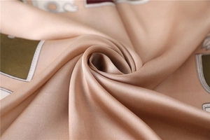 Vue macro d'un foulard en soie aux motifs équestres vintage champagne et olive