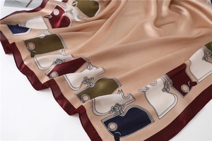 Détail d'un foulard en soie avec motif équestre et texture satinée champagne doré