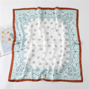 Detail eines Seidenschals mit Paisleymuster in Blau und Weiß sowie orangefarbenem Rand