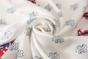 Detailaufnahme von weißem Seidenschal mit elegantem blau-rotem Paisley-Muster