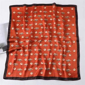 Detail of soft silk-like fabric with cute cartoon triceratops and balloon patterns