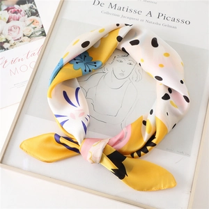 Detail van een zijden sjaal met kleurrijke konijn- en polkadotpatronen in een knoop