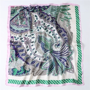 Dettaglio di sciarpa in seta con motivo paisley bohémien e accenti rosa e blu navy