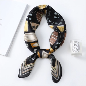 Detail of silk-feel scarf with black abstract handbag print on smooth satin fabric