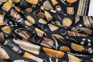 Close-up of silk scarf showing glossy texture and elegant handbag illustrations