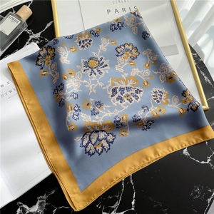 Elegant floral silk square scarf in blue and yellow on premium marble background