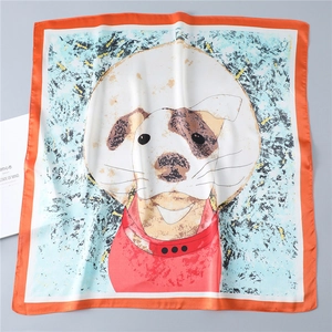 Detail van een zijden vierkante sjaal met cartoon hondenprint en oranje randafwerking