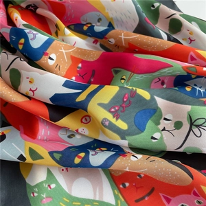 Detail van een vierkante zijden sjaal met kleurrijk kattenpatroon en gladde, zijdezachte textuur