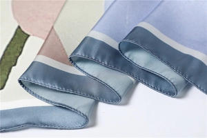 Detailopname van een zijden sjaal met elegante abstracte patronen en fijne zomen