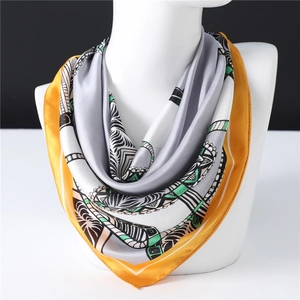 Mustard yellow square silk scarf with geometric print on a white mannequin torso