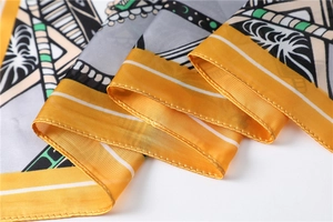 Close-up of a 70x70cm square silk scarf featuring yellow borders and tropical geometric prints