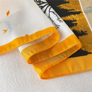 Detailopname van zijden sjaal met oranje bloemmotieven en silhouetten van bomen