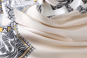 Detail view of the smooth satin texture and geometric ethnic patterns on the scarf
