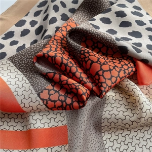 Close-up of leopard print silk scarf with multi-pattern stitching and smooth satin texture