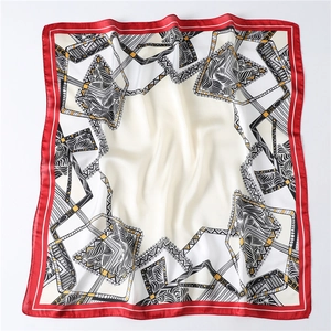 Close-up of geometric silk square scarf with red borders and intricate wavy patterns
