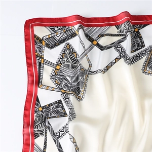 Macro detail of silk square scarf featuring zebra stripes and vibrant red borders