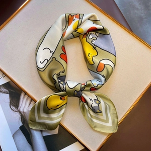 Detail van een zijden sjaal met cartoon kattenprint en olijfgroene randafwerking