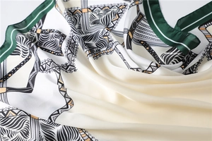 Detailed close-up of printed satin silk scarf showing elegant folds and texture