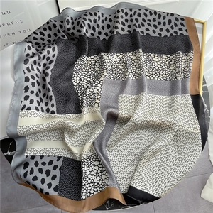 Detail of silk-like leopard print square scarf showing geometric honeycomb patterns