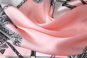Detailed view of the smooth pink silk satin fabric with elegant wave patterns on the edges