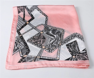 Detail of pink silk square scarf featuring modern geometric patterns and satin finish